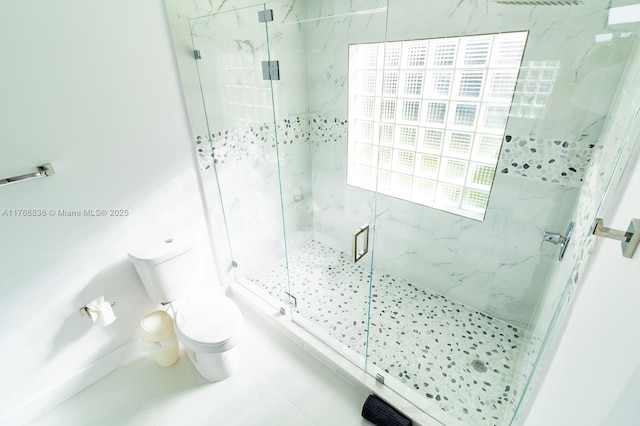 bathroom with a marble finish shower and toilet