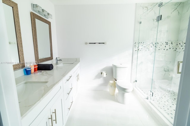 bathroom featuring toilet, a sink, a marble finish shower, and double vanity