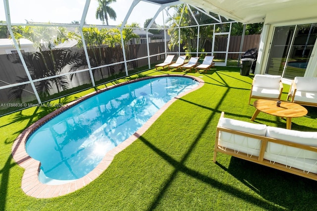 view of pool featuring glass enclosure, a fenced in pool, a fenced backyard, and a yard
