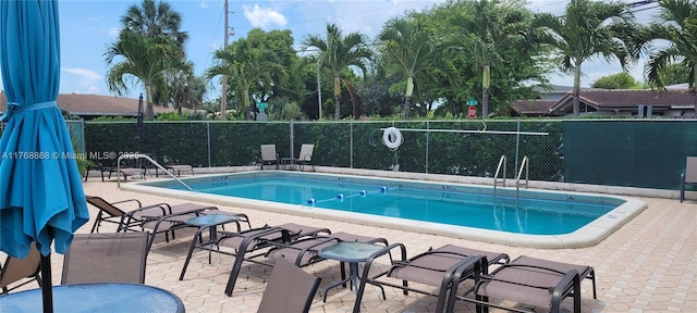 community pool featuring a patio and fence
