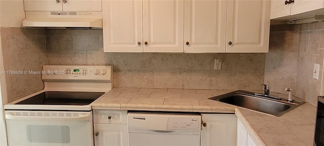 kitchen with white appliances, a sink, white cabinets, under cabinet range hood, and tasteful backsplash