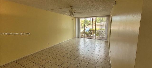 spare room featuring baseboards, expansive windows, light tile patterned flooring, a textured ceiling, and a ceiling fan