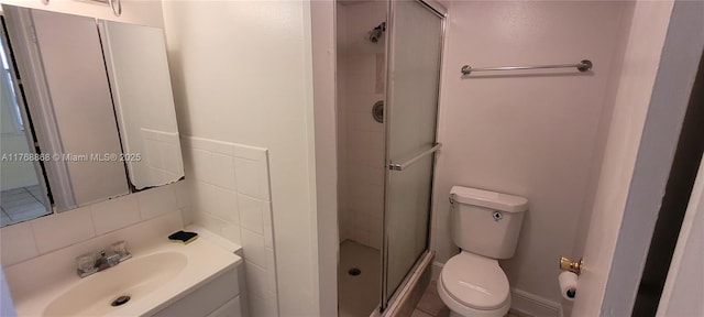 bathroom featuring decorative backsplash, a stall shower, toilet, and vanity