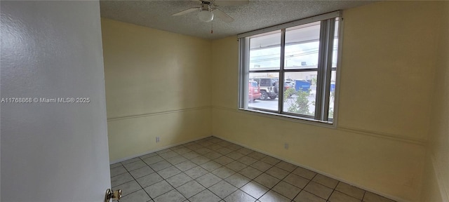 unfurnished room featuring light tile patterned floors, a ceiling fan, and a textured ceiling