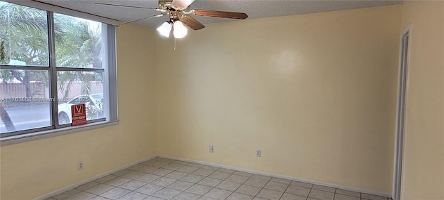 spare room with light tile patterned floors, baseboards, and a ceiling fan