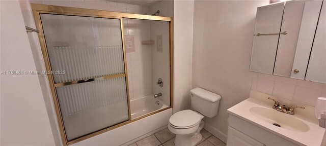 bathroom featuring vanity, bath / shower combo with glass door, tile patterned flooring, toilet, and tasteful backsplash