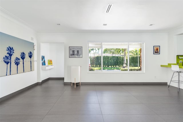 unfurnished room featuring baseboards, visible vents, and crown molding