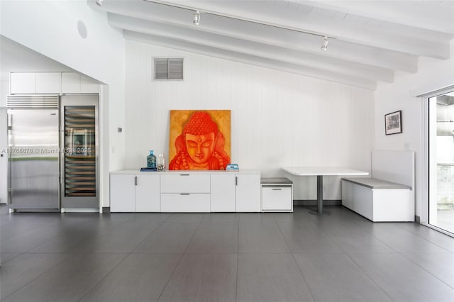 501 NE 51st St, Miami, FL 33137 - bar featuring stainless steel built in fridge, beverage cooler, track lighting, and wooden walls