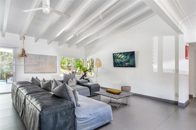 living area featuring baseboards, vaulted ceiling with beams, and ceiling fan