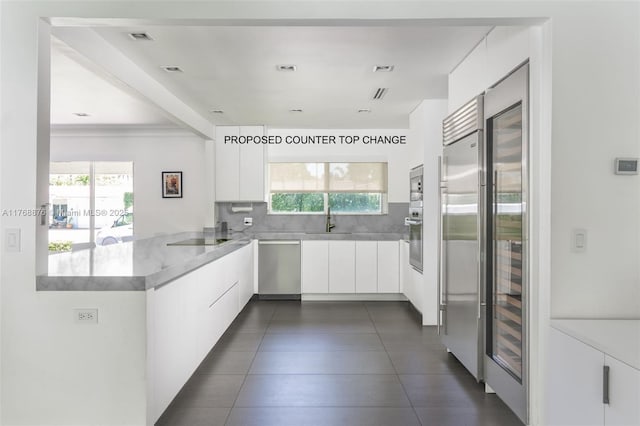 kitchen featuring a sink, white cabinetry, tasteful backsplash, appliances with stainless steel finishes, and modern cabinets