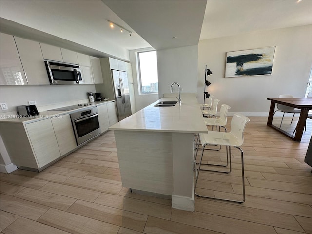 2600 E Hallandale Beach Blvd Unit T2202, Hallandale Beach, FL 33009 - kitchen with a kitchen breakfast bar, appliances with stainless steel finishes, light wood-type flooring, a sink, and track lighting