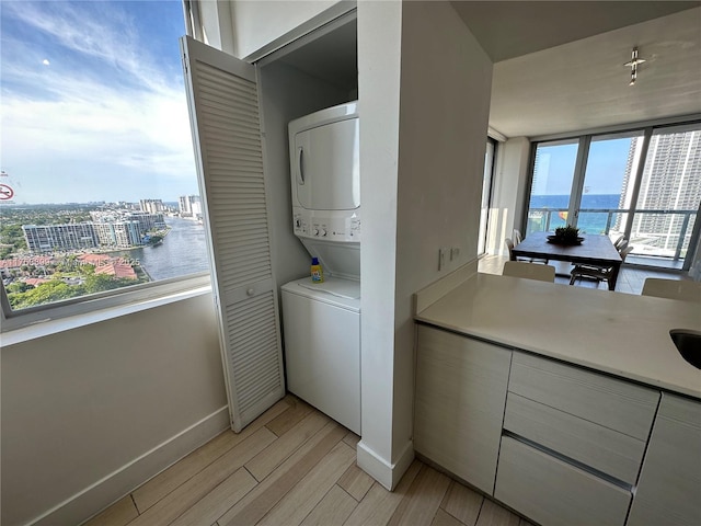 2600 E Hallandale Beach Blvd Unit T2202, Hallandale Beach, FL 33009 - laundry area with laundry area, stacked washer / dryer, baseboards, a view of city, and light wood finished floors