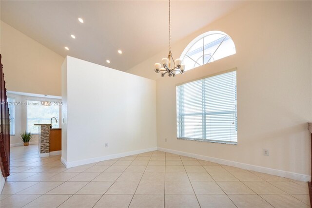 unfurnished room featuring recessed lighting, light tile patterned floors, high vaulted ceiling, baseboards, and a notable chandelier