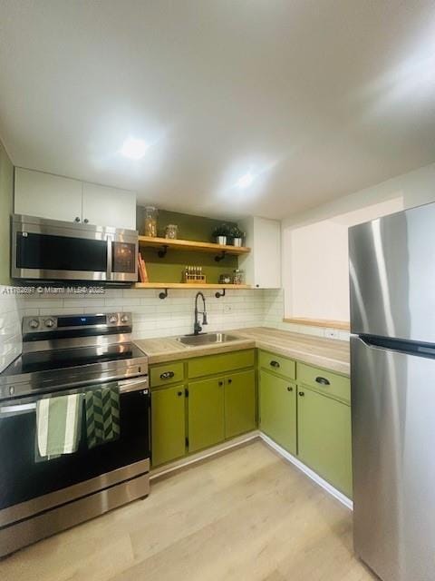 1101 Hillcrest Ct Unit 306, Hollywood, FL 33021 - kitchen featuring stainless steel appliances, a sink, green cabinets, light countertops, and tasteful backsplash