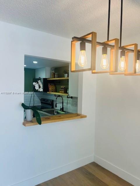 1101 Hillcrest Ct Unit 306, Hollywood, FL 33021 - kitchen featuring wood finished floors, baseboards, a textured ceiling, a sink, and black electric range oven