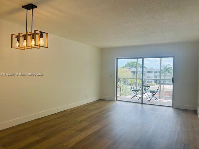 1101 Hillcrest Ct Unit 306, Hollywood, FL 33021 - spare room with a chandelier, baseboards, and dark wood-style floors