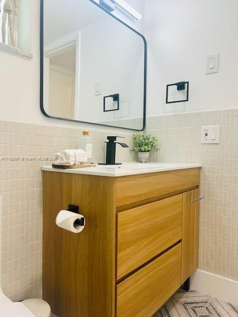 1101 Hillcrest Ct Unit 306, Hollywood, FL 33021 - bathroom featuring tile walls, vanity, a wainscoted wall, and toilet