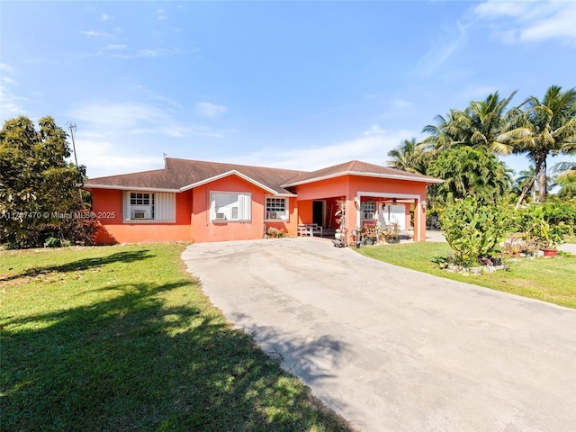 single story home featuring stucco siding, a front yard, and concrete driveway