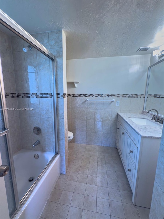 1103 NW 58th Ter Unit 224, Sunrise, FL 33313 - full bathroom featuring tile walls, bath / shower combo with glass door, tile patterned flooring, vanity, and toilet