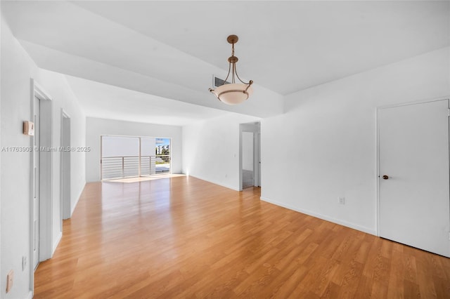 empty room featuring light wood finished floors, baseboards, and visible vents