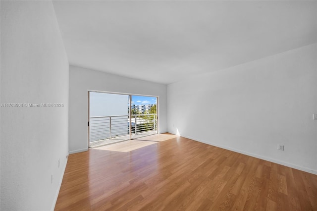 unfurnished room with light wood-style flooring and baseboards