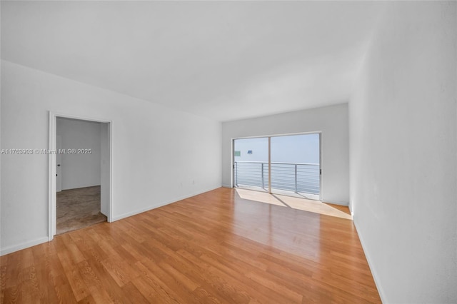 unfurnished room featuring light wood-style flooring and baseboards