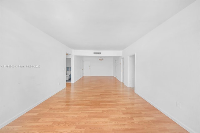 spare room with light wood-type flooring, baseboards, and visible vents