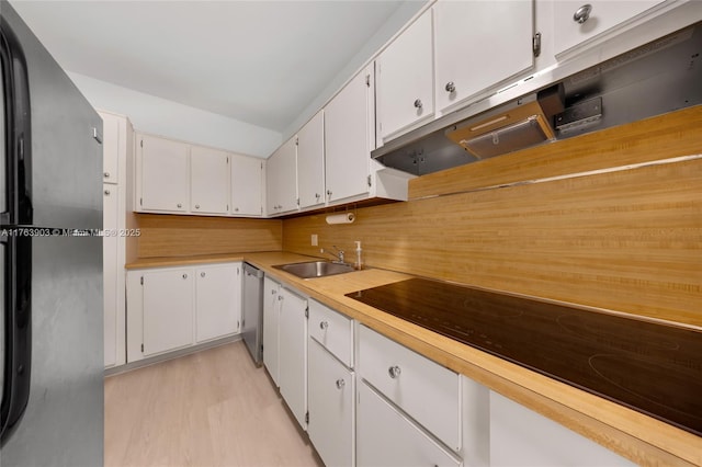 kitchen featuring white cabinets, light countertops, dishwasher, a sink, and freestanding refrigerator