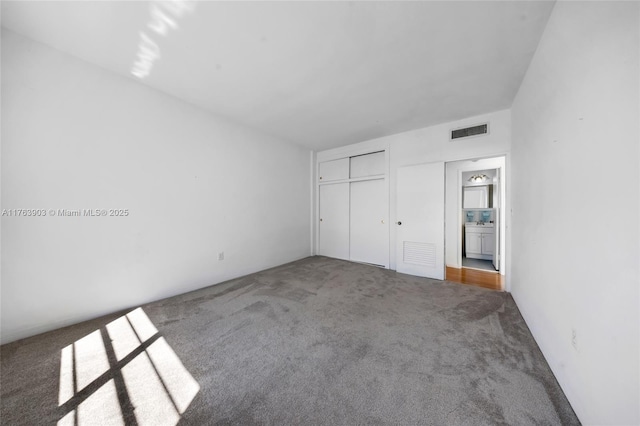 unfurnished bedroom featuring visible vents, carpet floors, and a closet