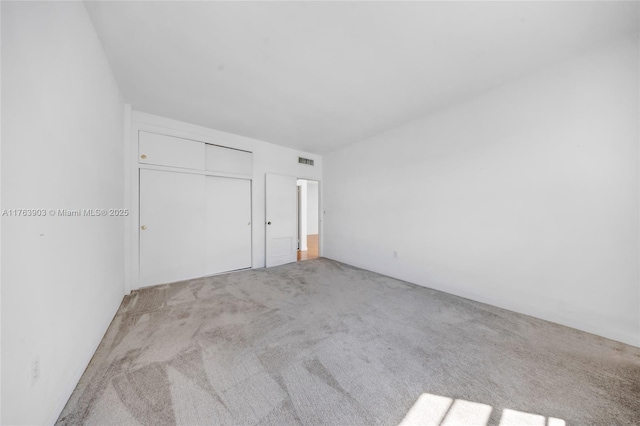 carpeted empty room featuring visible vents