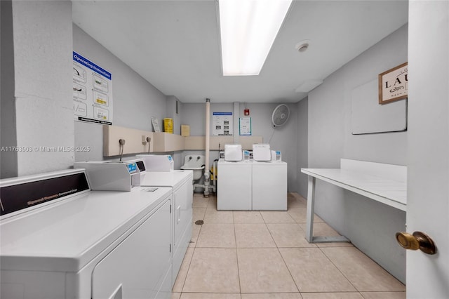common laundry area with washing machine and clothes dryer and light tile patterned floors