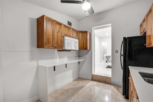 5241 Redwood Ct, Plantation, FL 33317 - kitchen featuring a ceiling fan, brown cabinetry, white microwave, visible vents, and freestanding refrigerator