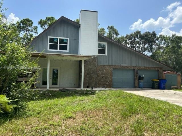 1616 Churchill St, Lake Placid, FL 33852 - exterior space with driveway, a front lawn, stone siding, a garage, and board and batten siding