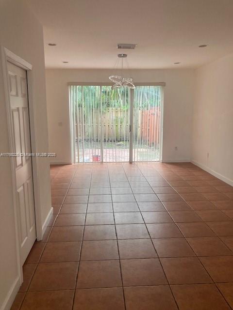 5450 NW 107th Ave Unit 705, Doral, FL 33178 - tiled spare room featuring a chandelier, visible vents, and baseboards