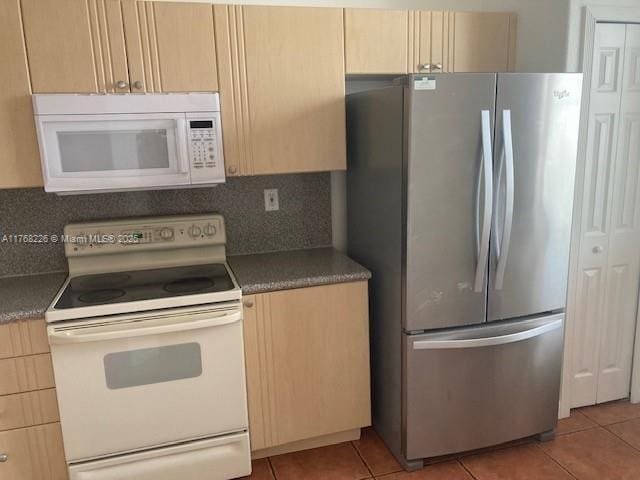 5450 NW 107th Ave Unit 705, Doral, FL 33178 - kitchen with light tile patterned floors, light brown cabinets, white appliances, and tasteful backsplash