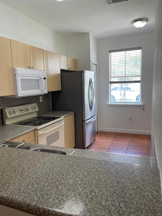 5450 NW 107th Ave Unit 705, Doral, FL 33178 - kitchen with white appliances, light brown cabinetry, and dark countertops