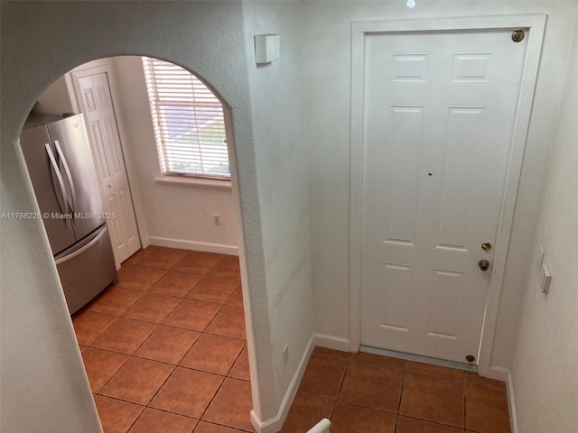 5450 NW 107th Ave Unit 705, Doral, FL 33178 - interior space with light tile patterned floors, arched walkways, baseboards, and a textured wall