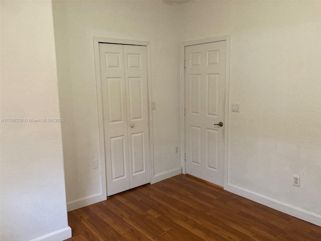 5450 NW 107th Ave Unit 705, Doral, FL 33178 - unfurnished bedroom with dark wood-style floors and a closet