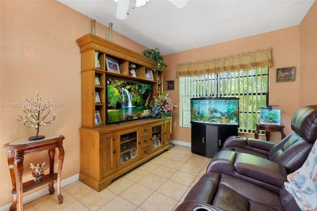 living area featuring light tile patterned flooring, baseboards, and a ceiling fan