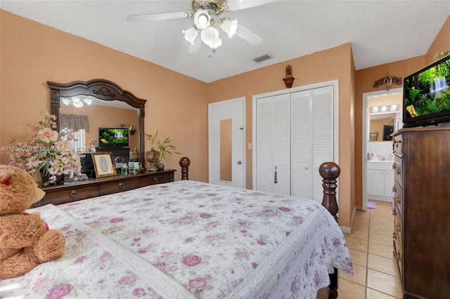 bedroom with visible vents, a ceiling fan, a textured ceiling, a closet, and light tile patterned floors