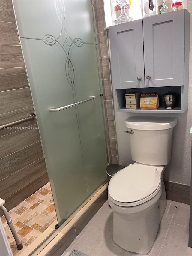 full bathroom with tile patterned floors, a shower stall, and toilet
