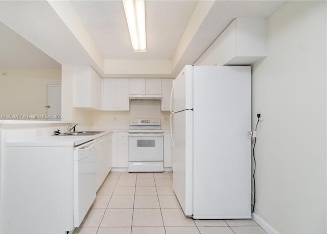 5530 NW 61st St Unit 303, Coconut Creek, FL 33073 - kitchen with white appliances, under cabinet range hood, light tile patterned floors, white cabinetry, and light countertops
