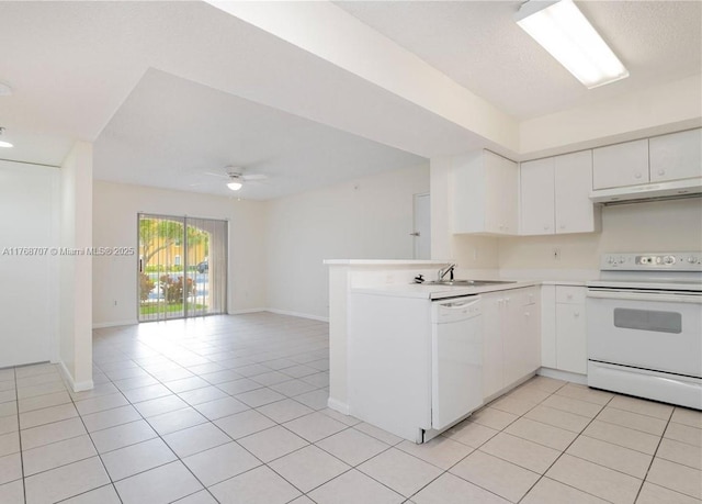 5530 NW 61st St Unit 303, Coconut Creek, FL 33073 - kitchen featuring white appliances, under cabinet range hood, light tile patterned flooring, and a peninsula