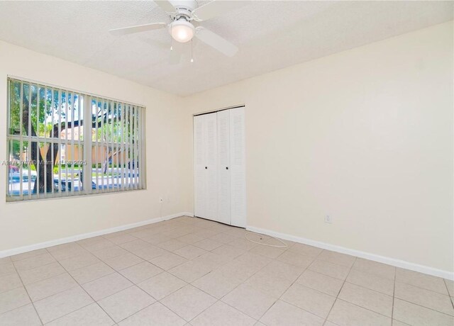 5530 NW 61st St Unit 303, Coconut Creek, FL 33073 - spare room with baseboards and a ceiling fan