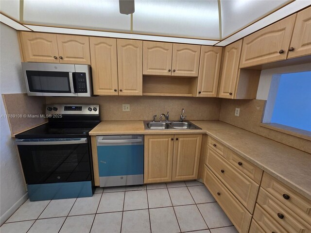 kitchen featuring tasteful backsplash, appliances with stainless steel finishes, light countertops, and a sink