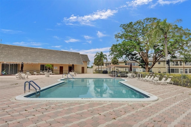 community pool featuring fence and a patio