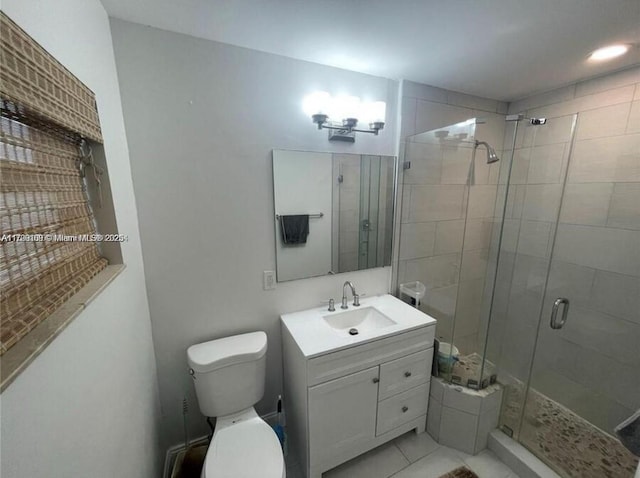 bathroom with a shower stall, toilet, vanity, and tile patterned flooring