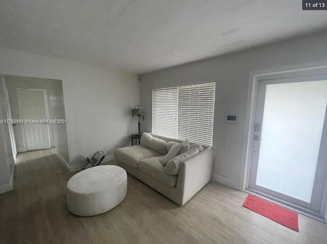 living area with baseboards and wood finished floors