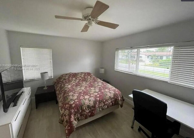 bedroom featuring wood finished floors, baseboards, and ceiling fan