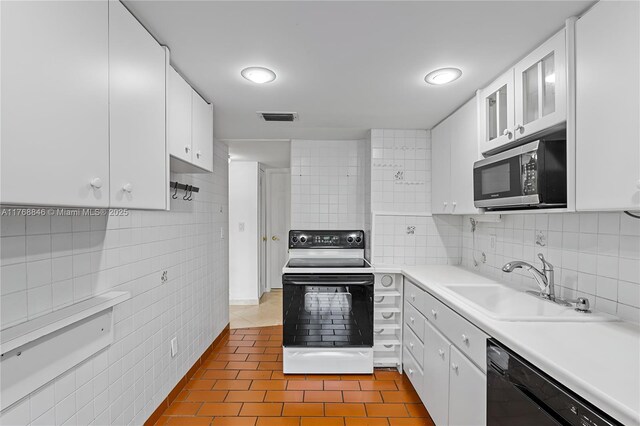77 Crandon Blvd Unit 2B, Key Biscayne, FL 33149 - kitchen featuring black appliances, dark tile patterned floors, tile walls, white cabinetry, and light countertops